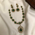 Green gemstone necklace and earrings on a white fabric background